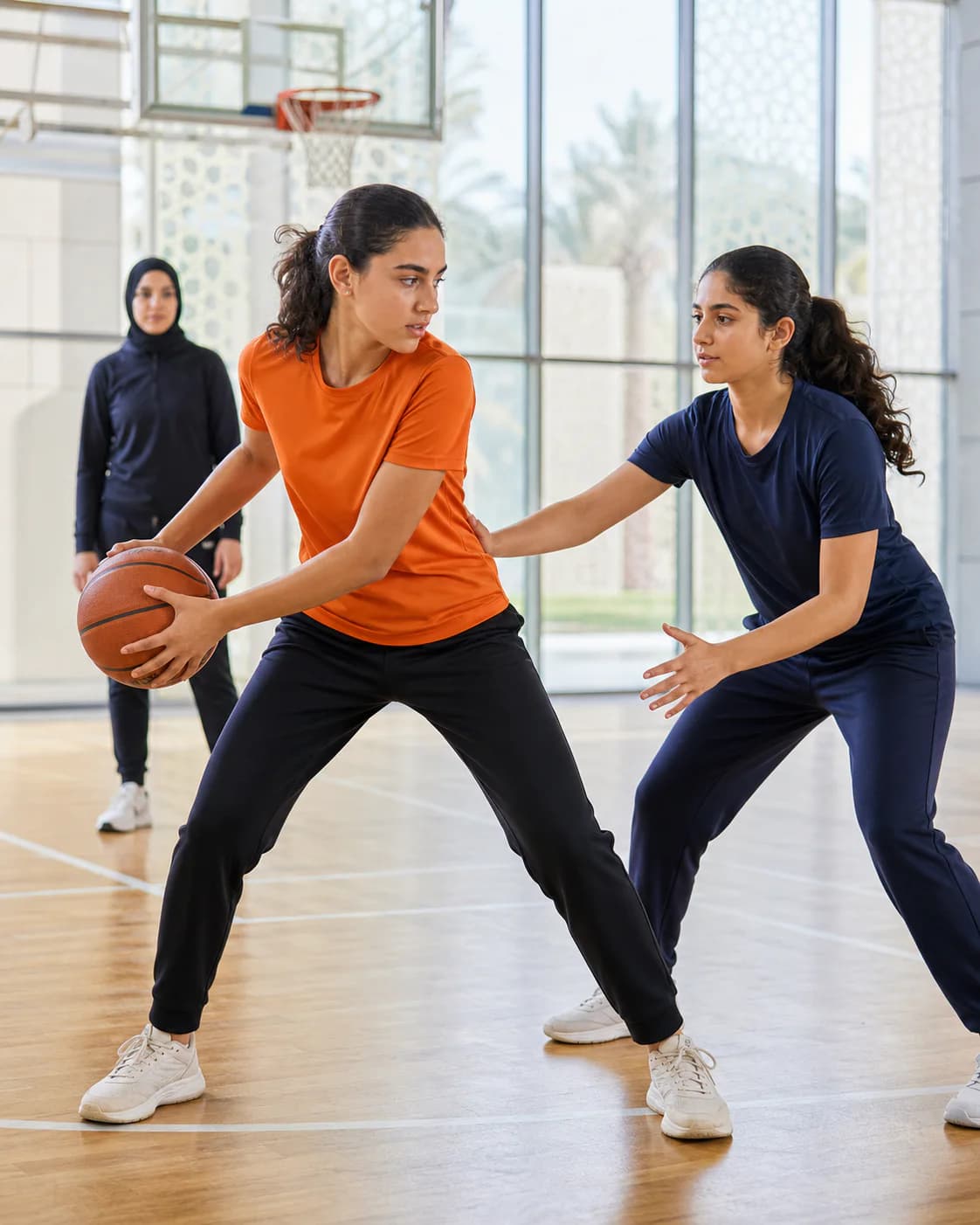 Girls practising a strong pivot and controlled defence during basketball training in Abu Dhabi