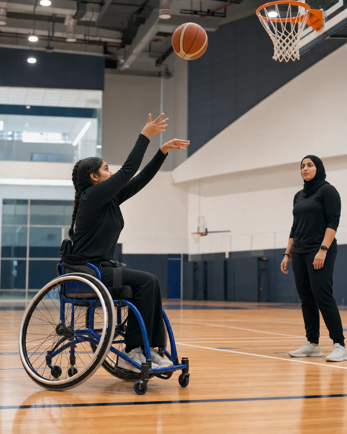 Young wheelchair basketball player taking a set shot while her coach observes
